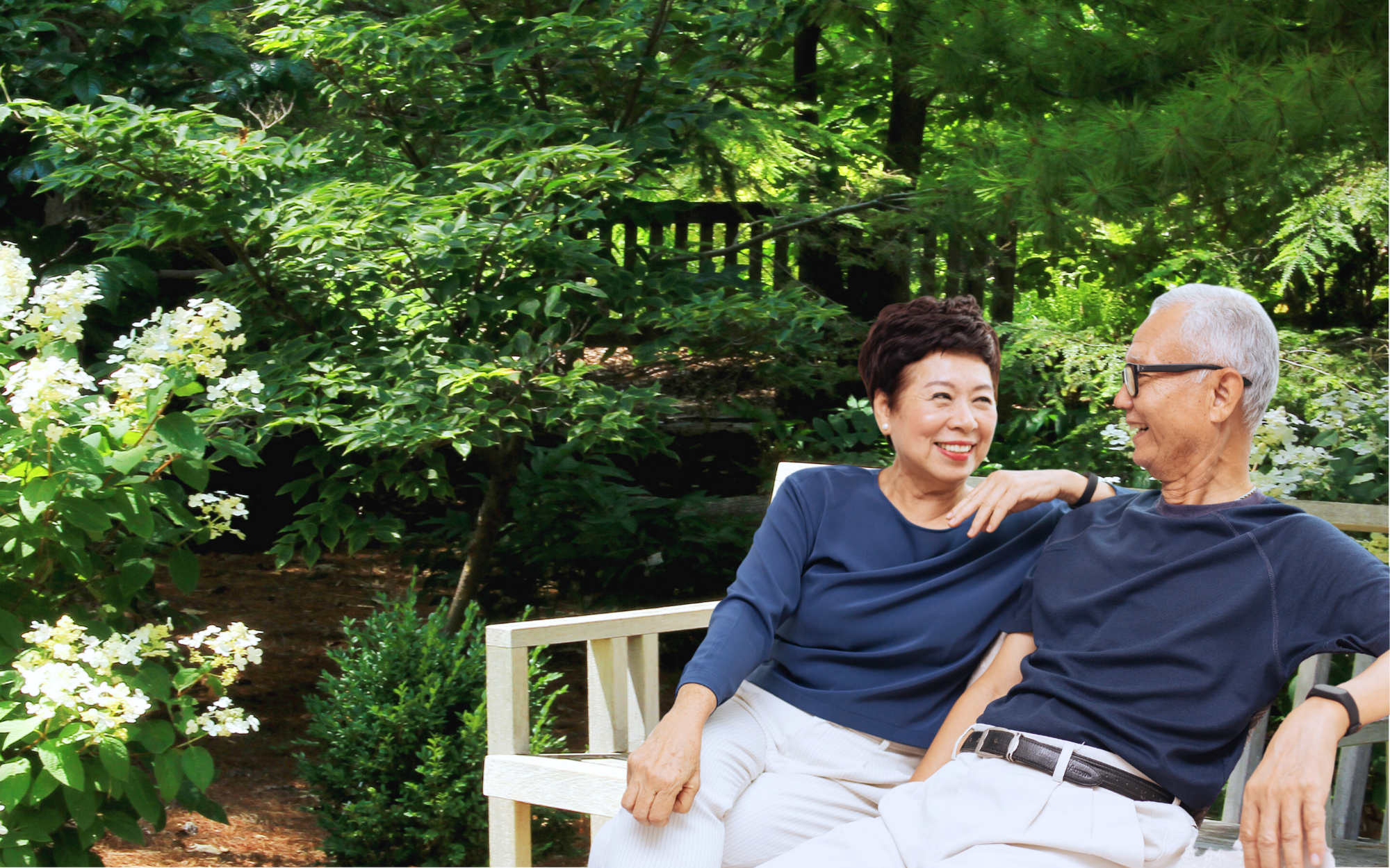 Senior couple relaxing on a garden bench — eldercare services at Allium Healthcare Singapore